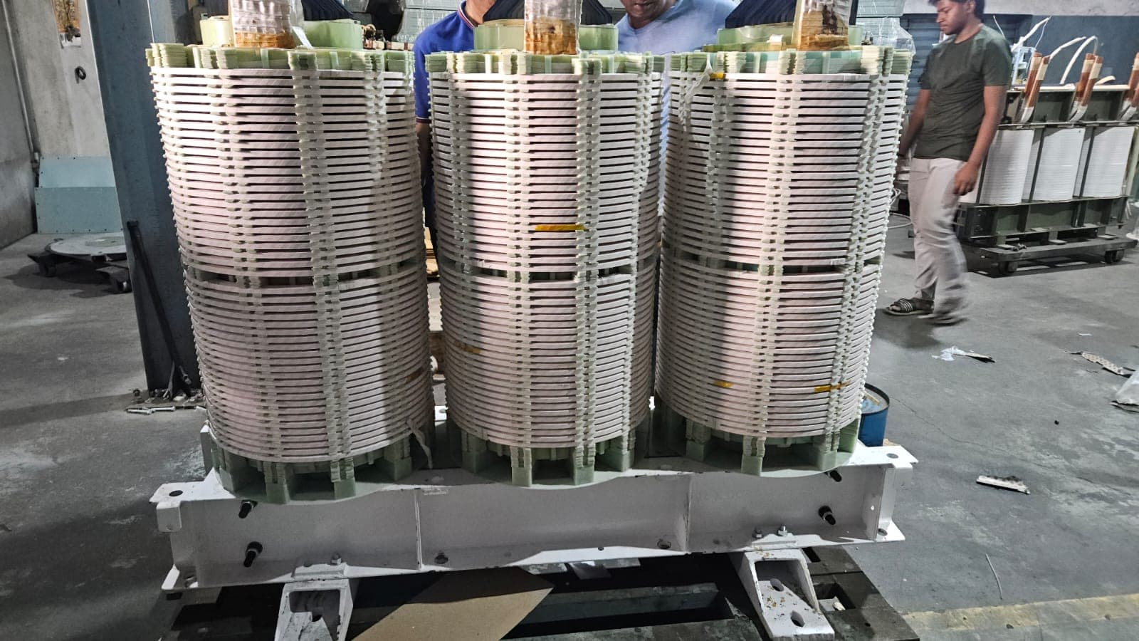 HV and LV disc windings being assembled onto the core limbs by technicians at Tula Trans Electricals, Surat