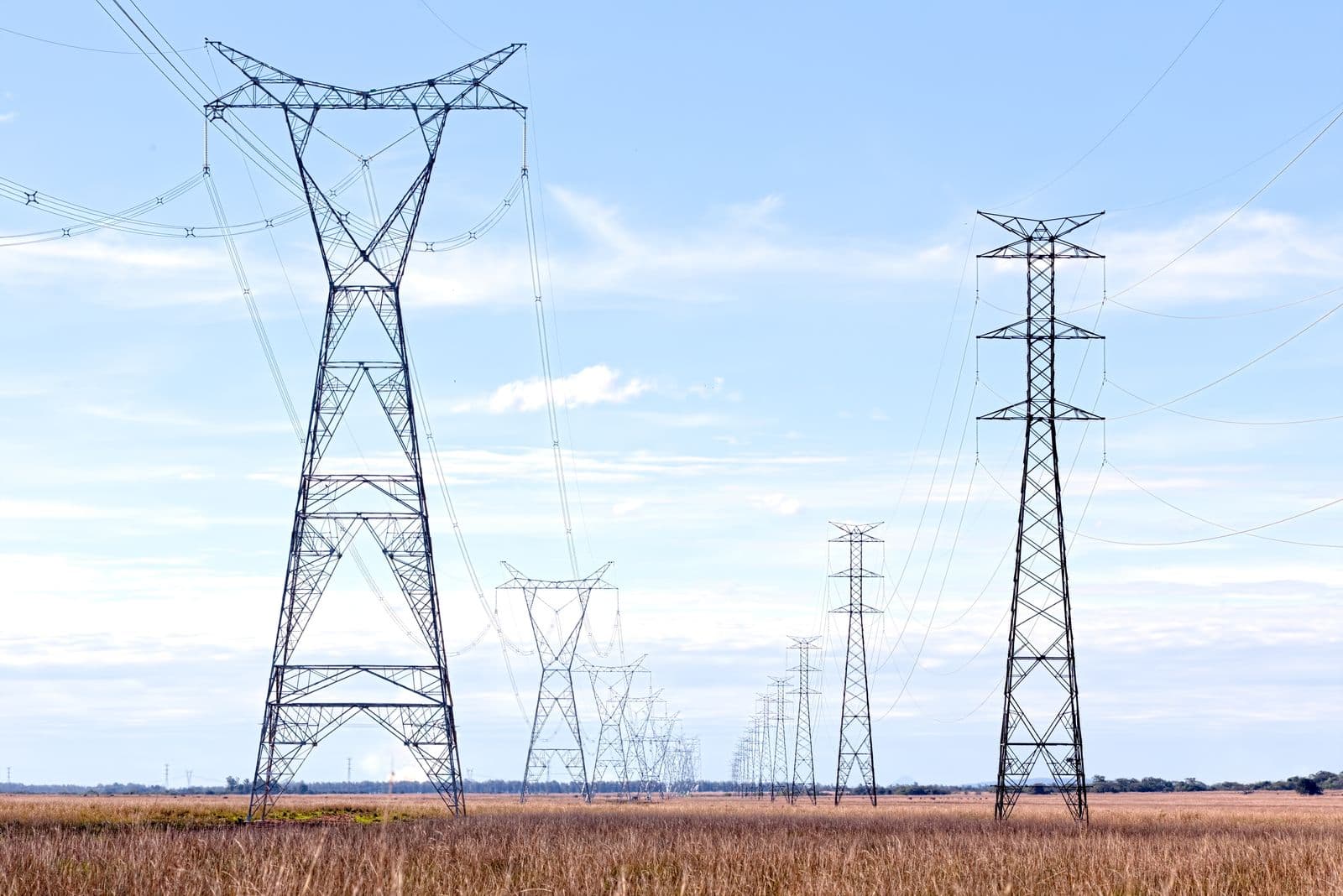 High-voltage transmission pylons carrying power lines across open countryside